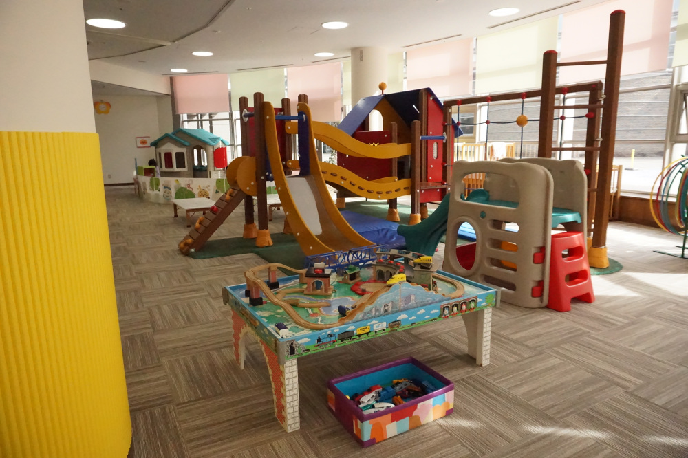 広々とした室内に乗り物のおもちゃや大型遊具